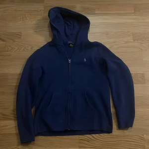 Blå Polo Raulph Lauren hoodie - Hej säljer en blå Raulph Lauren hoodie. Den är använda fåtal gånger eftersom jag växte ur den väldigt snabbt. Det är storlek 14-16 barn men passar dig cirka 155-165. Den har inga defekter och ligger på nypris cirka 1100 kronor köpt på Kidsbrandstore. Den passar perfekt som en hoodie att göra dig lite varmare under den kommande hösten och vintern😊