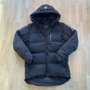 Sail Racing jacka - Svart dunjacka från Sail racing antartica. Jackan är i extremt bra skick inprincip aldrig använd. Fylld med 500 fill power dun från Allied Feather + Down. Perfekt för kalla dagar så den är otroligt varm. Skriv vid minsta fundering