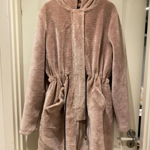  teddyjacka med huva och snörning - Supermjuk och fluffig  teddyjacka från boohoo med huva och dragsko i midjan för snygg passform. 