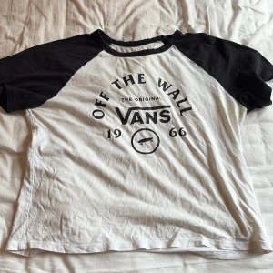 Svartvit Vans t-shirt med tryck - Säljer min svartvit t-shirt från Vans med tryck fram på bröstet. Storlek barn large men passar en s också, men modellen är lite kortare. Säljs på grund av att den inte kommer till användning längr.