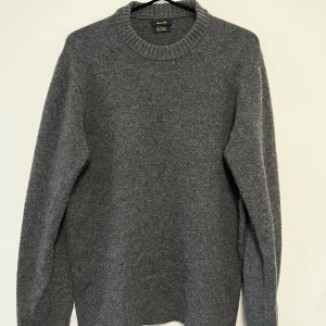 Grå stickad tröja från Massimo Dutti - Riktigt snygg strickad Kashmir ull tröja från Massimo Dutto. Tjock och varm så den är perfekt nu till höst och vinter månaderna. Modellen är 182 cm lång och väger ca 70 kg