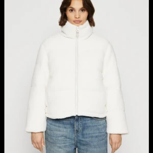 Beige teddyjacka med dragkedja - Mysig beige teddyjacka från Only .med hög krage och hel dragkedja framtill. Jackan har en loose passform och långa ärmar, perfekt för kyliga dagar. Den fluffiga ytan ger en trendig look och jackan är enkel att matcha till olika outfits.