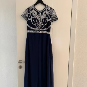 Mörkblå långklänning med paljetter Boohoo - Klänningen är från Boohoo. Den har lite stygn på sidan som gått upp, kan skicka bild vid förfrågan. Storlek 40.