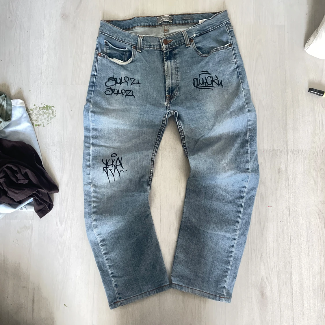 Ljusblå jeans med graffiti