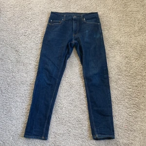 Mörkblå Levi's 511 jeans herr - Säljer ett par mörkblå  jeans från tiger of sweden. Jeansen har normal midja och är tillverkade i slitstark bomullsdenim. Perfekta för dig som gillar en tidlös och clean look. Sitter lite loose fast samtidigt slim som ger en perfekt look. Bara att höra av sig vid funderingar. Priset är ej hugget i sten.