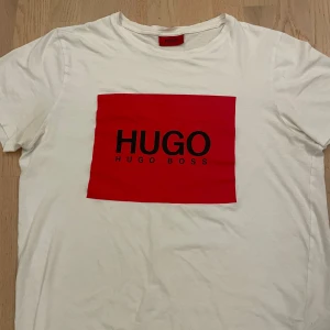 vit röd hugo boss t-shirt - Säljer denna hugo boss tröja eftersom jag knappast andvänder den längre. Helt nytt skick och sitter perfekt. Har andvänt 2-4 gånger. Nypris: 550kr