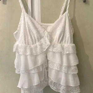 Vit söt linne topp volanger coquette boho chic spets blommor spetslinne somrig babydoll milkmaid - Spetslinne med fina detaljer. Axelbanden är reglerbara. Storlek XS!