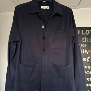 Mörkblå mocka overshirt från Studio Total - Snygg mörkblå overshirt från Studio Total med klassisk krage och tre framfickor. Jackan har knäppning med svarta knappar och är långärmad. Perfekt att slänga på över en t-shirt för en chill look.