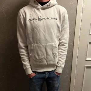 Sail Racing hoodie  - Säljer en vit Sail Racing hoodie i 9/10 skick sparsamt använd och i topp kvalitet. Tröjan är i storlek M och modellen är 183cm. Nypris: 1300