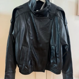 Viral  skinnjacka med hög krage, Zara - Säljer den virala skinnjackan från Zara med cool asymmetrisk knäppning och hög krage. 