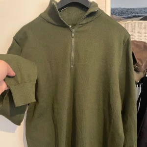 Olivgrön stickad tröja - Stickad tröja som aldrig har använts. Materialkvaliteten är tunnt.