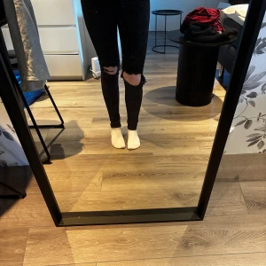 Svarta jeans - Svarta skinny jeans från Dr Denim, modell Lexy, med slitna och trasiga knän för en edgy look. Klassisk femficksdesign, hög midja och stretchigt material som sitter tajt. Perfekta för dig som gillar streetstyle och vill ha ett par riktigt snygga svarta jeans. Full längd, syns bara inte på bilderna, har alltid haft dom uppvikta så dom är inte slitna nertill.