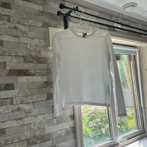 Vit långärmad tröja från Pieces - En basic vit långärmad tröja från Pieces i mjuk bomull. Enkel och clean design med rund halsringning, perfekt att styla lager på lager eller som den är. Snygg passform som funkar till allt och är ett måste i garderoben.