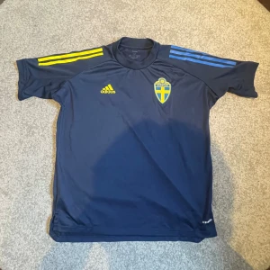 Adidas T-shirt Sverige  - Tja! Säljer denna Mörkblå landslagstshirt från Adidas, dessa är spelare i landslaget som använder och går ej att köpa så dom är väldigt limiterade i mängden! Storlek M