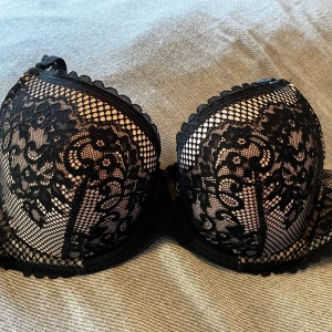 Svart-rosa spets-BH från Hunkemöller - Säljer en superfin svart-rosa BH från Hunkemöller i storlek 85C. Den har ett detaljerat blommigt spetsmönster och meshpartier som ger en snygg och lyxig känsla. Perfekt för dig som gillar eleganta och feminina underkläder med extra stöd och form. Sparsamt använd och givetvis tvättad.