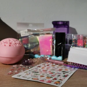 27 nagelartiklar, bla. Semilac 575 - Säljer ett set med 16 små burkar nagelglitter i färger som orange, rosa, lila, blå, silver och svart. Inkluderar även Semilac Bridesmaid Like You 575 (minst 75% av produkten kvar) 2 ark för julnaglar, pensel samt andra tillbehör. Perfekt för dig som älskar färg och glitter på dina naglar. Värde på över 260 kr
