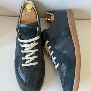 Maison Margiela mörkblå sneakers i mocka - Säljer nu mina Maison Margiela gats. Skorna är i nyskick och låda är med. Dom är 45 men passar 44. Hör va er vid minsta fråga! Pris kan diskuteras