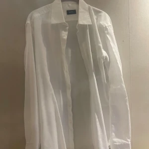 Vit rutig skjorta från Hugo Boss - Säljer nu min vita Hugo boss skjorta som jag beställde för ett tag sen men kom i för stor storlek så säljer den till nån som kanske passar bättre i den. Skjorta har en diskret rutigt mönster. Skjortan har lång ärm, knappar framtill och en stilren krage. Perfekt för dig som gillar en clean och tidlös look. Materialet är tunn och lätt 