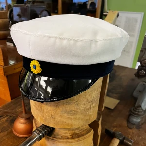 Klassisk studentmössa Uppsala (Blå strimma) 52-63 - Klassisk studentmössa med vit mösskulle i bomull, blått band och blank svart skärm. Framtill sitter en klassisk kokard. Insidan har det klassiska foder i blått och gult. Uppsala-modell. Finns storlekar från 52–63. Berätta till storlek innan du lägger en beställning. (Limiterat lager) 