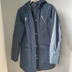 Mörkblå klassiker från Elvine - Parkajacka från Elvine i storlek medium. Sparsamt använd. Man kan se att den blivit tvättad (se bild på fickan) men inget annat att anmärka på. 