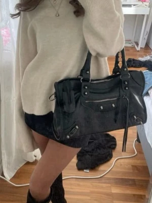 Svart handväska med dragkedjedetaljer - Stilren svart handväska i skinn med silverfärgade metalldetaljer och flera dragkedjor framtill. Väskan har dubbla handtag och en klassisk, rymlig form som passar till många outfits. City bag💕🤍🫶✨👍🏼