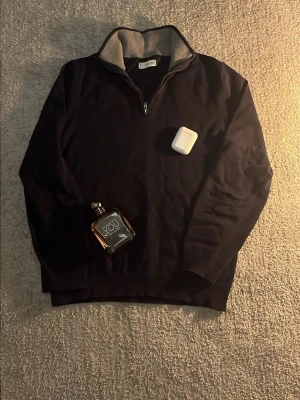 Mörkblå halvzip från MNG - Mörkblå tröja med halv dragkedja från MNG. Insidan av kragen är ljusgrå och ribbstickad, vilket ger en snygg kontrast. Perfekt för lager-på-lager och har en klassisk, stilren look med lång ärm.