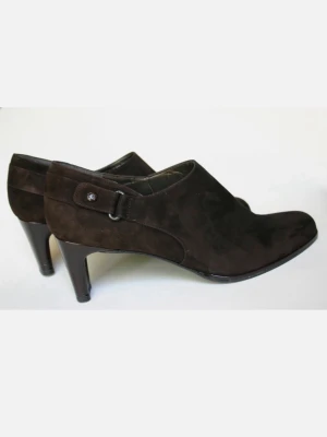 Bruna mocka pumps med spetsig tå - Snygga bruna pumps i mocka med spetsig tå och hög klack. Skorna har en stilren design med dekorativ knappdetalj på sidan. Perfekta för dig som gillar klassiska och eleganta skor.