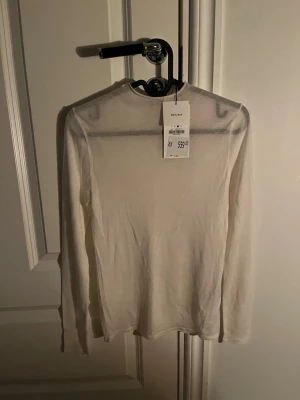 Långärmad Zara tröja - Jätte fin tröja ifrån Zara, jag säljer den för den inte passade tyvärr! Den är gjord i 30% silke och 70% ylle vilket gör den väldigt skön! Den är L men fungerar för nån som är M!