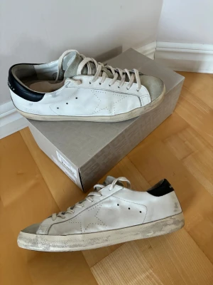 Jättefina Golden goose superstar - Galet snygga trendiga Golden goose superstar skor i storlek 45. Alla slitningar är en del av designen och dem är till och med snyggare i verkligheten! Grymt skick använda mycket försiktigt. Og box finns och nypris på över 5000 kr! Tveka inte att höra av er vid minsta fråga eller fundering😃