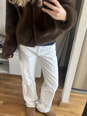 Vita Zara jeans straight low waist  - Säljer ett par vita jeans med rak passform och klassisk femficksdesign. Jeansen har normal midja och är tillverkade i bomull, vilket gör dem både bekväma och stilrena. Perfekta att matcha med allt i garderoben.