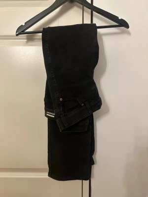 Svarta jeans från Dedicated - Snygga svarta jeans från Dedicated men köpt från Nellys hemsida. De är i bra skick, lite urtvättade men håller fortfarande färg. De är stretchiga och sitter lite tightare nertill men inte skinny. 