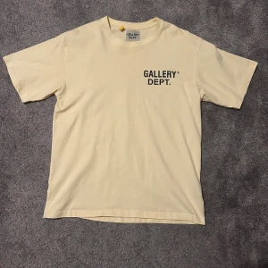 Gallery Dept. t-shirt - Snygg sand färgad t-shirt från Gallery Dept. med tryck både bak och fram. passformen är rätt så baggy. Perfekt för dig som gillar streetwear och enkel stil. Storleken är M men skulle säga att det är mer M/L då det är så baggy i just armarna. Hör av er vid minsta fråga och priset är ej hugget i sten