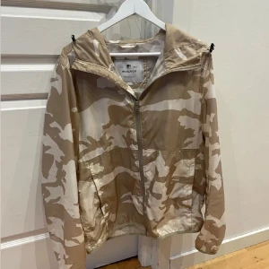Woolroch Windbreaker - Unik Beige/Vit Camo Windbreaker från Woolrich. Storlek: L. Skick: 9/10, väldigt fint skick! Kontakta oss för fler bilder eller info!🙌