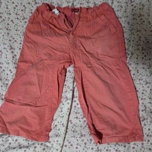 Korallfärgade loose shorts Coaster - Säljer ett par korallfärgade shorts från Coaster Industries i loose fit. De har elastisk midja, dragkedja och fickor både fram och bak. Materialet är mjuk bomull, perfekt för chill dagar. Passar dig som gillar avslappnad stil och bredare ben.