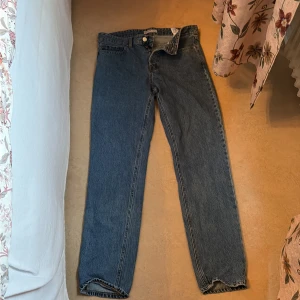 Blå regular fit jeans 32/34 - Säljer ett par klassiska blå jeans från C Denim i regular fit med raka ben och normal passform. Jeansen har fem fickor, knapp och dragkedja fram samt en snygg läderpatch bak. Perfekt för dig som gillar enkel och tidlös stil.