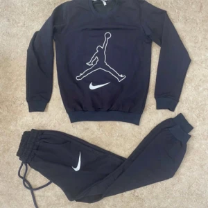 Svart Nike tröja med Jumpman-logga - Svart långärmad tröja från Nike med stor vit Jumpman-logga och swoosh på bröstet. Tröjan har rund halsringning och ribbade muddar vid ärmslut och nederkant. Perfekt för dig som gillar sportig och stilren streetwear.