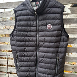 Colmar väst - Snygg svart dunväst från Colmar med quiltad design och dragkedja framtill. Västen har två fickor med dragkedja och en hög krage. Perfekt för lager-på-lager och har en stilren look med Colmar-logga på bröstet.