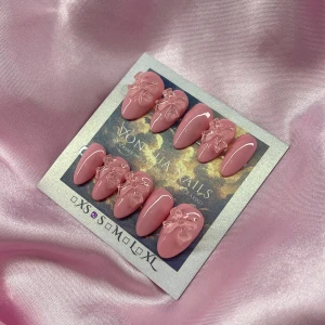 CandyBow (S);Short Almond;Curved - Snygga handgjorda press-on naglar i en mjuk rosa nyans med glansig finish. Naglarna har en kort almondform och är dekorerade med 3D-rosetter i transparent rosa. Perfekt för dig som vill ha en söt och trendig look.S: 15 mm, 11,5 mm, 12 mm, 11 mm, 9 mm 