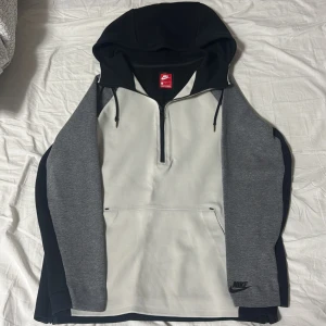 Gammal/Og nike tech  - Nike hoodie i svart, grått och vitt med half zip framtill och stor huva med snörning. Tröjan har långärmade grå ärmar, svart rygg och vita paneler fram. Praktisk magficka och dragkedjor längs sidorna. Perfekt för chill eller träning.