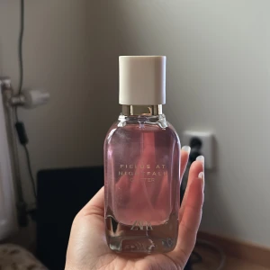 Fields at Nightfall Glitter parfym - Trendig parfym från ZARA med rosa toner i flaskan och stilren design. Perfekt för dig som vill ha en snygg accessoar på hyllan. Namnet 'Fields at Nightfall Glitter' ger en hint om en modern och ungdomlig känsla.