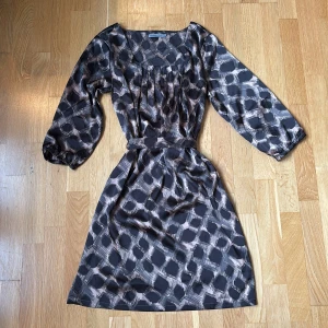 mönstrad klänning med band - superfin klänning i brun beige mönster med ett band till!!