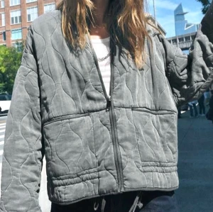 Zara jacka  - Säljer en grå quiltad jacka med dragkedja, jackan har ett vågigt quiltat mönster och en loose passform, använd fåtal gånger!!