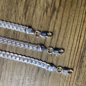 Säljer tre snygga kedjearmband i pläterade silver 925 - Säljer tre snygga kedjearmband i pläterade silver 925. Klassisk platt kedja med blänkande yta och karbinlås. Perfekt för dig som gillar stilrena och tidlösa smycken. Passar både som statement eller att kombinera med andra halsband. Längd 21, bredd 5,mm