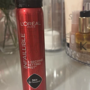 L'Oréal Infaillible Setting Mist - L'Oréal Infaillible 3-Second Setting Mist i röd metallisk flaska. Ger makeupen en hållbar finish i upp till 36 timmar utan att sminka av sig på kläder. Perfekt för att fixera din look snabbt och enkelt.