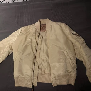 Beige jacka från Alpha Industries  - Säljer en beige från Alpha Industries i storlek medium. Köpt för 1700kr. 