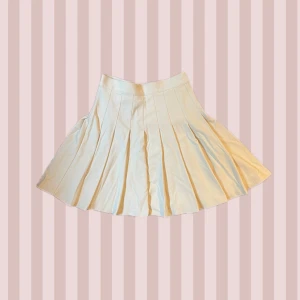 Beige tenniskjol från Monki - Supersöt ljusbeige tenniskjol från Monki i kort modell. Har bara använts 2 gånger! Den har en clean dragkedja och gullig knapp på sidan. Hör av dig om du har några frågor! <3 