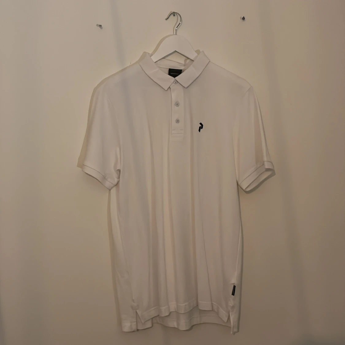 Vit pikétröja med liten logga