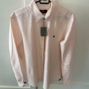 Randig skjorta från Morris  - Säljer en helt ny randig Morris skjorta i storlek M, modellen är slimfit. Modellen på bilden är ca 180 cm lång. Hör av dig vid funderingar!