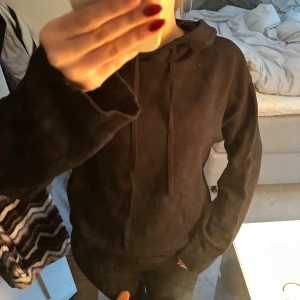 Svart stickad hoodie med huva - Svart hoodie från Shein med stickad känsla och huva. Tröjan har långa ärmar, snörning vid halsen och en loose passform. Perfekt för chill dagar och enkel att matcha med jeans eller leggings.