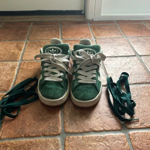 Adidas Campus gröna sneakers strl 36 - Säljer Gröna Adidas Campus sneakers i mocka. Skorna har rund tå, platt sula och snörning. Adidas logga på plös och häl. Extra gröna skosnören medföljer. 